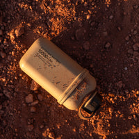 Beige colored 10000N battery pack laying in dirt 
