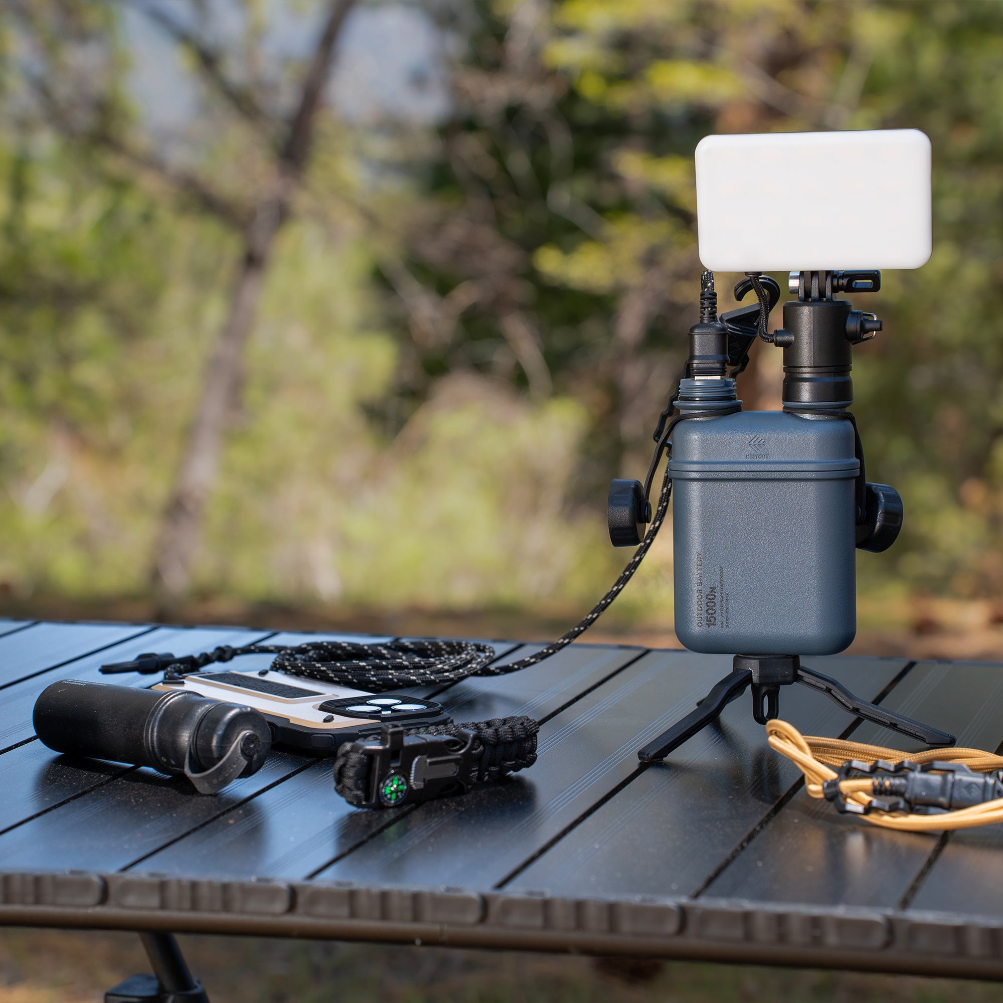 image of nestout 15k grey battery connected to smartphone nestout black flash on a table at jenks lake