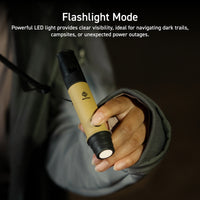 beige and black whistle light being used as a flashlight | person wearing grey jacket shines flashlight in the dark | overlay text reads: Flashlight Mode: Powerful LED light provides clear visibility, ideal for navigating dark trails, campsites, or unexpected power outages.