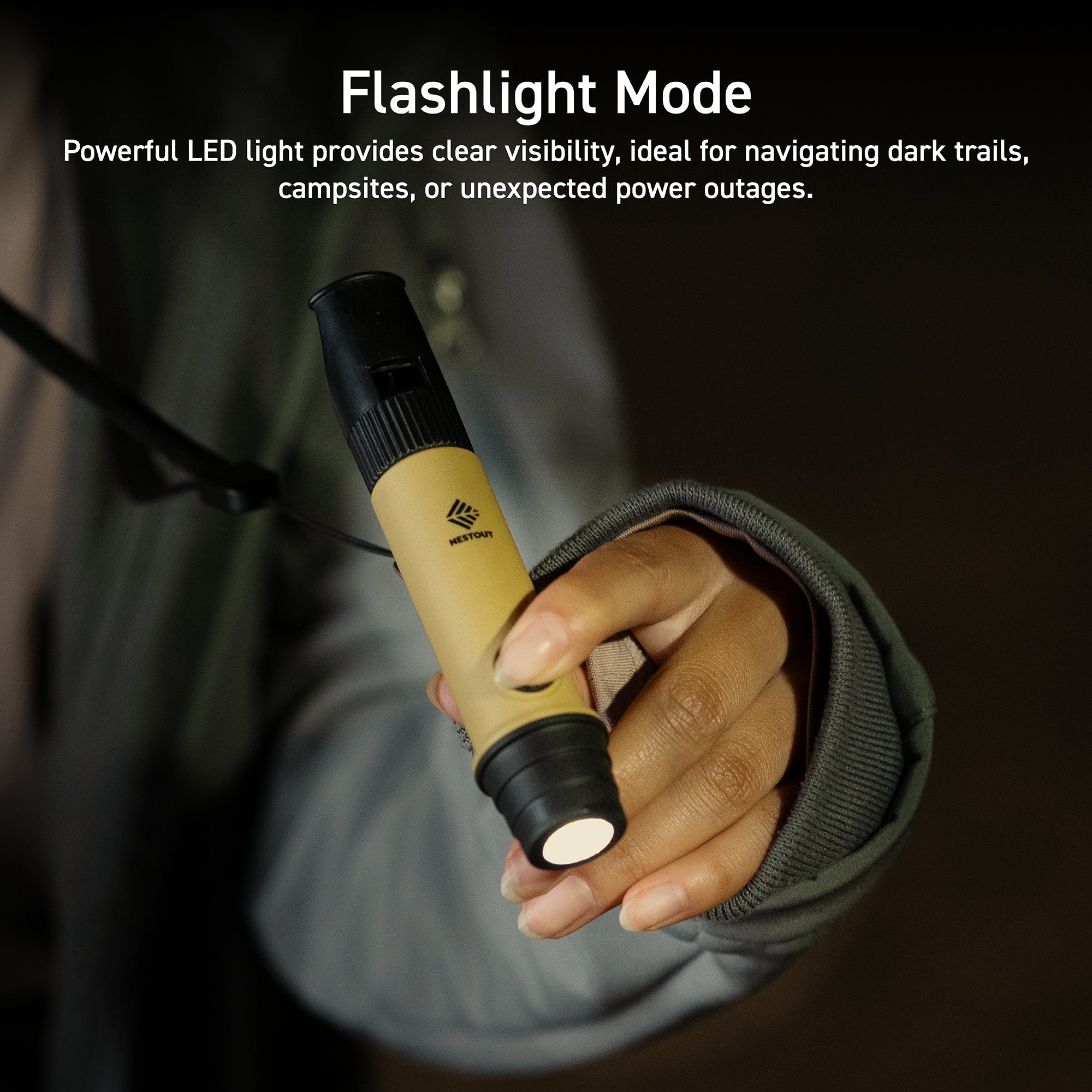 beige and black whistle light being used as a flashlight | person wearing grey jacket shines flashlight in the dark | overlay text reads: Flashlight Mode: Powerful LED light provides clear visibility, ideal for navigating dark trails, campsites, or unexpected power outages.