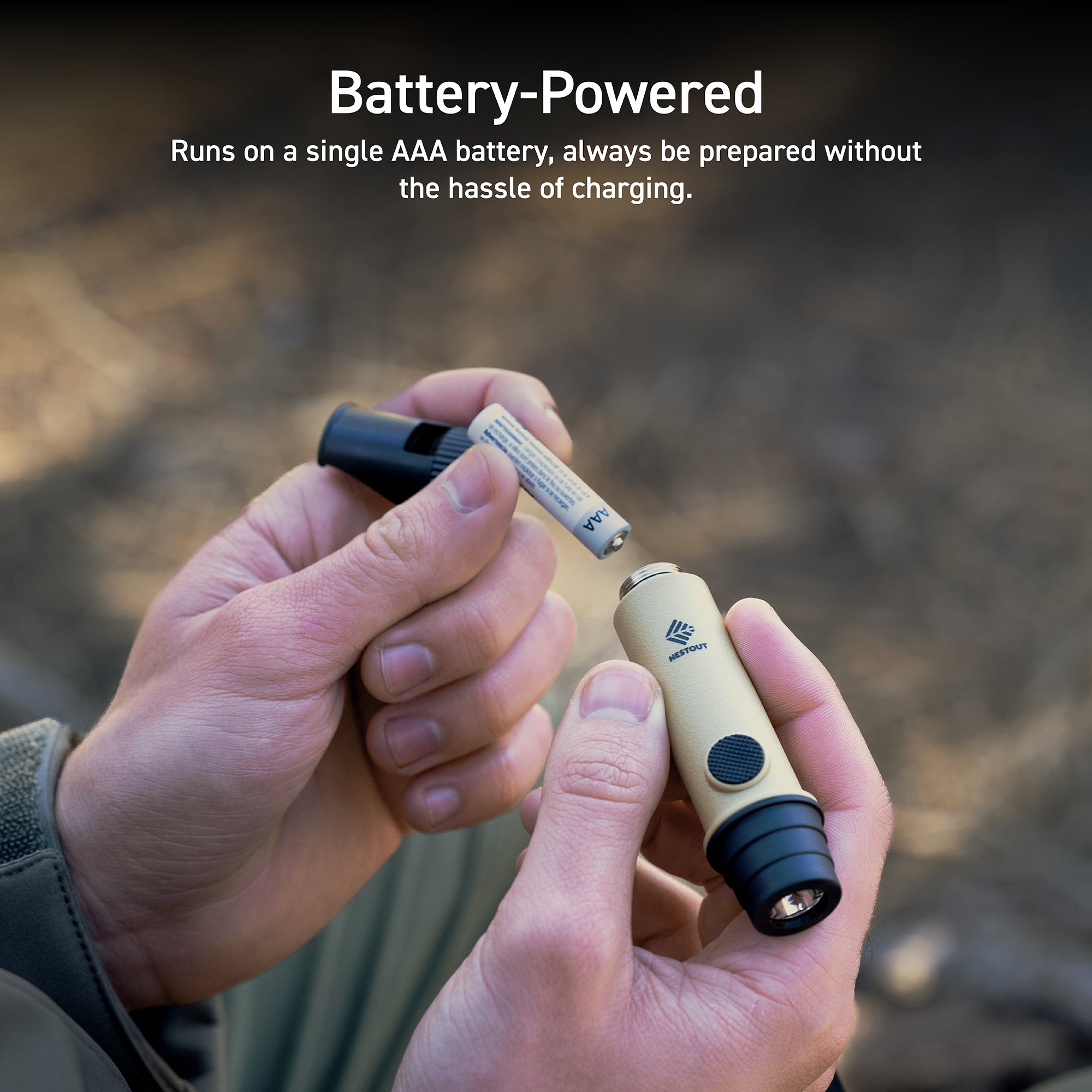person holding the NESTOUT beige whistle light with AAA batteries | sunlit patch of outdoors ground shown in the background | overlay text reads: battery-powered: runs on a single AAA battery, always be prepared without the hassle of charging